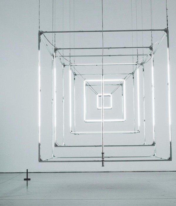 Intriguing geometric light installation in a minimal gallery setting.